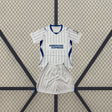 Equipación Brighton 26-27 Visitante de niño con camiseta blanca de líneas verticales azules y pantalón blanco con detalles azules