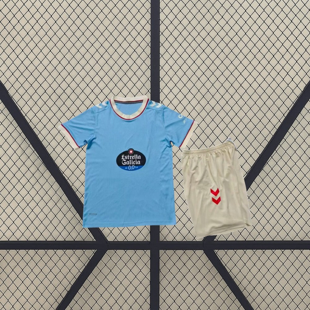 Equipación Celta de Vigo 26-27 local infantil con camiseta azul celeste de cuello crema y pantalón corto crema con detalles rojos