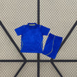 Equipación Chelsea 26-27 Local de niño con camiseta y pantalón azules, cuello tipo polo y detalles amarillos