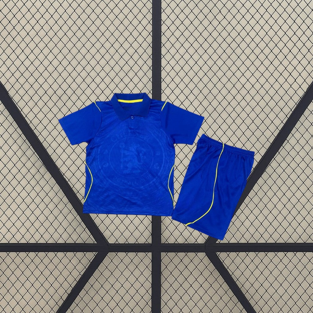 Equipación Chelsea 26-27 Local de niño con camiseta y pantalón azules, cuello tipo polo y detalles amarillos