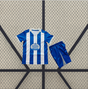 Equipación Deportivo La Coruña 26-27 local para niño con camiseta de franjas azules y blancas y pantalón corto azul a juego