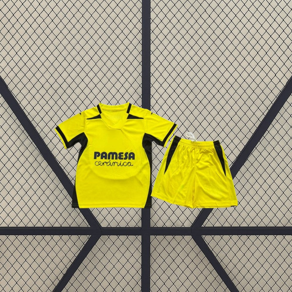 Equipación Villarreal 26-27 local niño vista frontal con camiseta amarilla de cuello en pico y pantalón corto amarillo con detalles oscuros