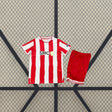 Equipación infantil Almería 26-27 local vista frontal con camiseta de rayas rojas y blancas y pantalón rojo