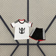 Equipación infantil Fulham 26-27 local vista frontal con camiseta blanca de detalles negros y rojos y pantalón negro