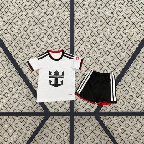 Equipación infantil Fulham 26-27 local vista frontal con camiseta blanca de detalles negros y rojos y pantalón negro