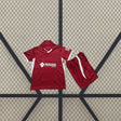 Equipación infantil Getafe 26-27 visitante con camiseta granate de cuello en V y detalles blancos, acompañada de pantalón corto granate