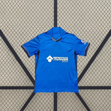 Vista frontal alternativa de la camiseta Getafe 26-27 local, con base azul, ribetes oscuros en cuello y mangas y paneles laterales en contraste