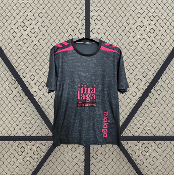 Vista frontal alternativa de la camiseta Malaga 26-27 tercera equipación con base oscura, detalles rosas en hombros y estampado tonal