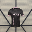 Vista frontal de la camiseta Alavés 26-27 visitante en negro, con patrón topográfico tonal, cuello redondo y ribetes rosas