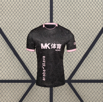 Vista frontal de la camiseta Alavés 26-27 visitante en negro, con patrón topográfico tonal, cuello redondo y ribetes rosas