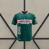 Vista frontal de la camiseta Albacete 26-27 Visitante verde con franja rosa en el pecho, detalles rosas en hombros y cuello redondo