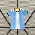 Vista frontal de la camiseta Argentina 26-27 de mujer edición conmemorativa de Lionel Messi en celeste y blanco con gráfico tonal