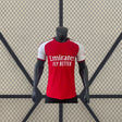 Vista frontal de la camiseta Arsenal 26-27 Local Player Version roja con mangas blancas, cuello redondo y corte ceñido