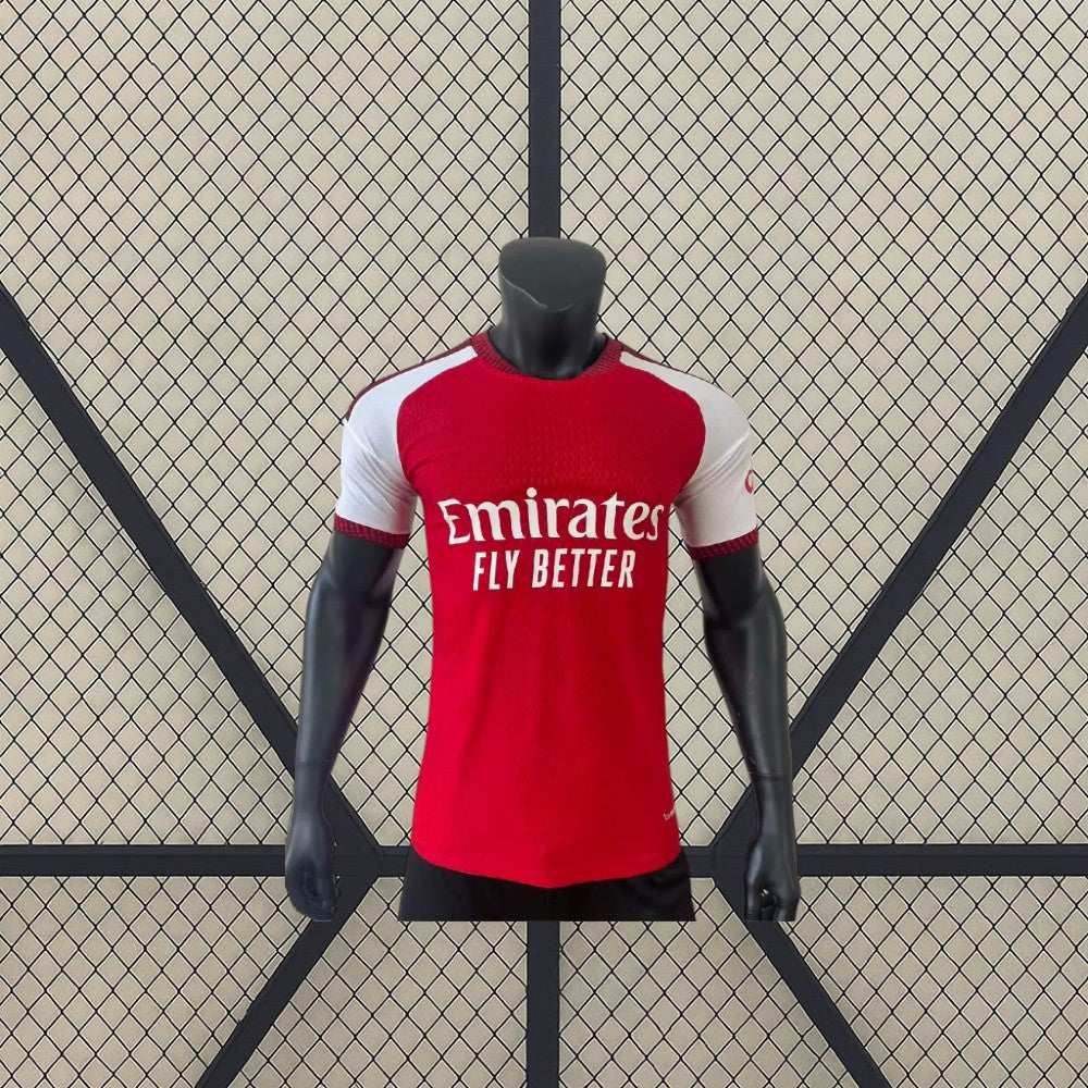 Vista frontal de la camiseta Arsenal 26-27 Local Player Version roja con mangas blancas, cuello redondo y corte ceñido