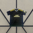 Vista frontal de la camiseta Aston Villa 26-27 Visitante con base negra, patrón tonal, detalles amarillos y cuello a contraste