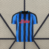 Vista frontal de la camiseta Atalanta 26-27 local con franjas verticales azules y negras, cuello redondo y paneles oscuros en los hombros