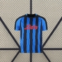 Vista frontal de la camiseta Atalanta 26-27 local con franjas verticales azules y negras, cuello redondo y paneles oscuros en los hombros