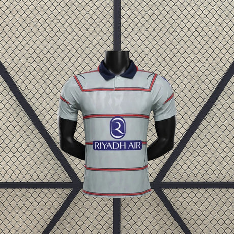 Vista frontal de la camiseta Atlético de Madrid 26-27 3ª equipación Player Version gris verdosa con franjas horizontales y cuello azul marino