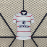 Vista frontal de la camiseta Atlético de Madrid 26-27 3ª equipación gris con franjas horizontales rojas y azules y cuello tipo polo