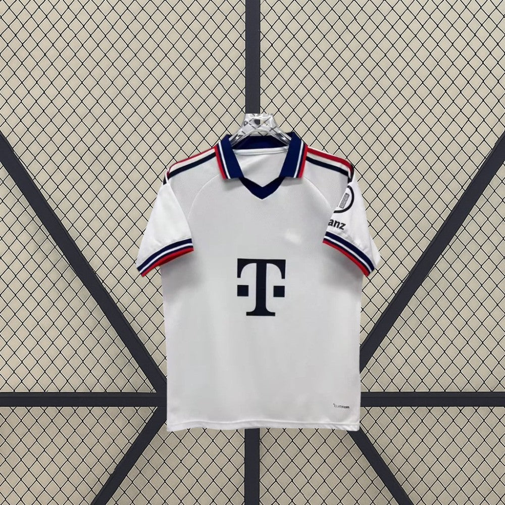 Vista frontal de la camiseta Bayern Munich 26-27 visitante en blanco, con cuello tipo polo, abertura en V y ribetes azules y rojos