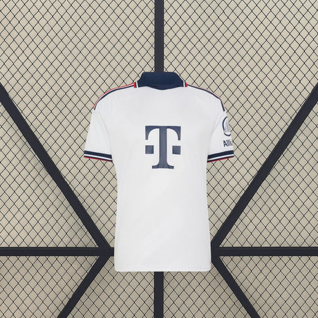 Vista frontal de la camiseta Bayern Munich 26-27 visitante en color blanco, con cuello azul marino y ribetes rojos y azules en mangas y hombros