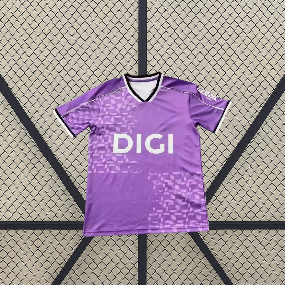 Vista frontal de la camiseta Burgos 26-27 tercera equipación en color morado, con cuello en V y patrón gráfico tonal en el frontal