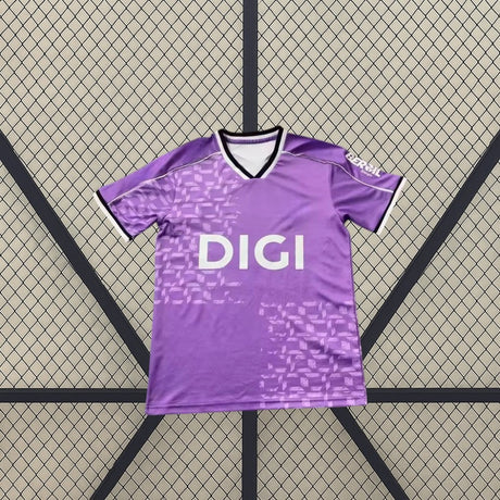 Vista frontal de la camiseta Burgos 26-27 tercera equipación en color morado, con cuello en V y patrón gráfico tonal en el frontal