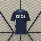 Vista frontal de la camiseta Cádiz 26-27 visitante en azul marino, con estampado tonal, cuello celeste y mangas cortas oscuras