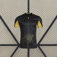 Vista frontal de la camiseta Córdoba 26-27 Visitante negra con mangas doradas, cuello contrastado y gráfico cartográfico en la zona inferior
