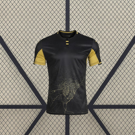 Vista frontal de la camiseta Córdoba 26-27 Visitante negra con mangas doradas, cuello contrastado y gráfico cartográfico en la zona inferior
