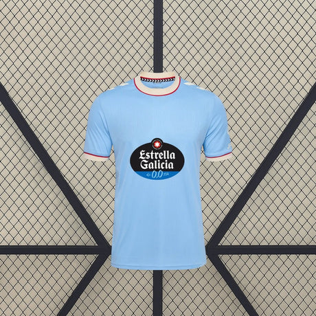 Vista frontal de la camiseta Celta de Vigo 26-27 local en azul celeste, con cuello redondo y ribetes en contraste