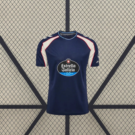 Vista frontal de la camiseta Celta de Vigo 26-27 visitante en azul marino, con paneles claros en hombros y mangas y detalles en rojo