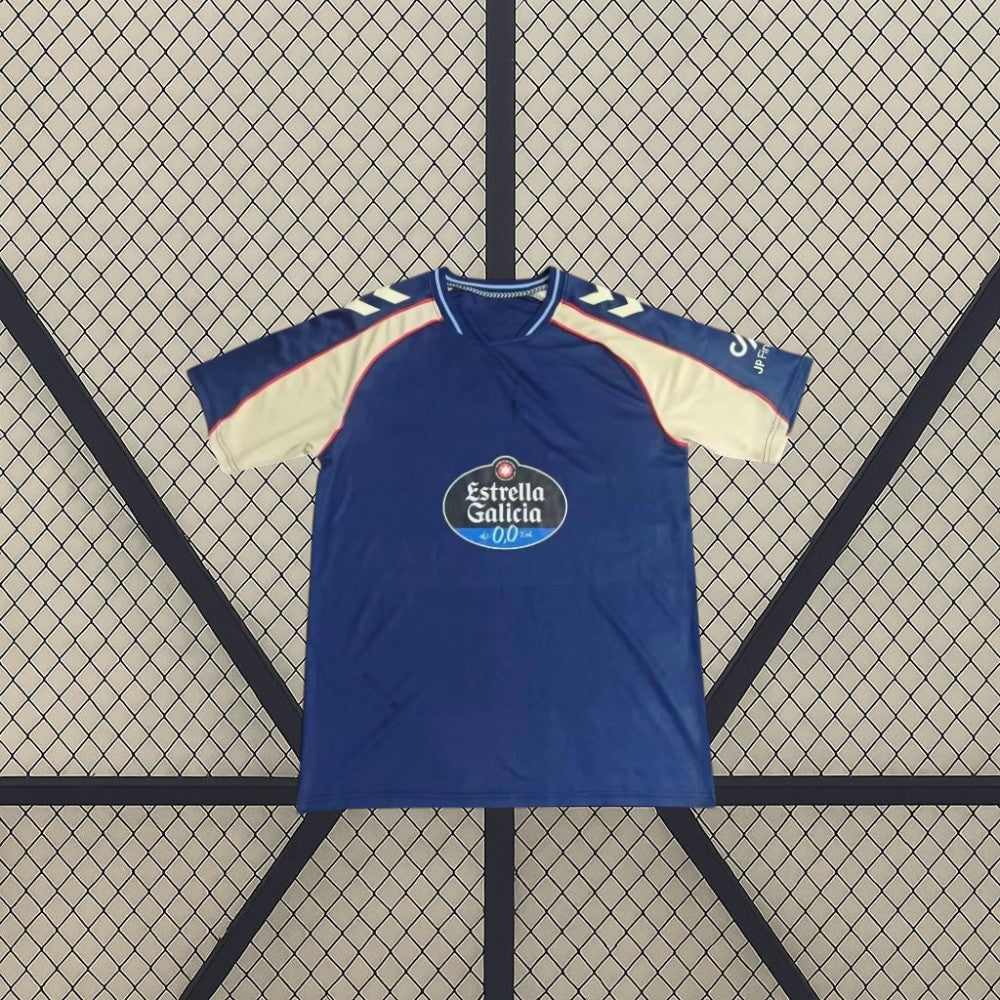 Vista frontal de la camiseta Celta de Vigo 26-27 visitante extendida, con base azul marino, mangas en contraste y cuello redondo