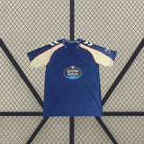 Vista frontal de la camiseta Celta de Vigo 26-27 visitante extendida, con base azul marino, mangas en contraste y cuello redondo