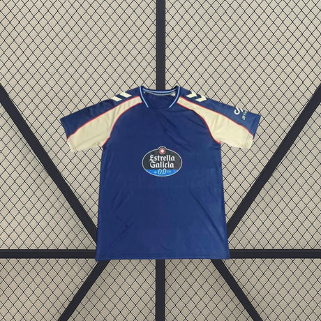 Vista frontal de la camiseta Celta de Vigo 26-27 visitante extendida, con base azul marino, mangas en contraste y cuello redondo