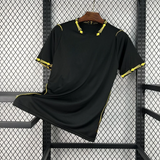 Vista frontal de la camiseta Chelsea 26-27 visitante en color negro, con cuello en pico y detalles amarillos en cuello y mangas