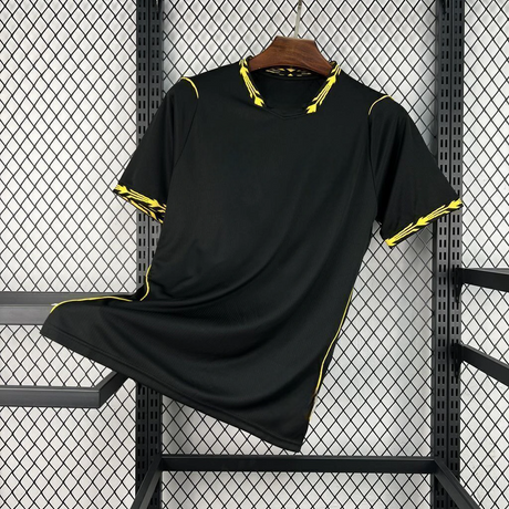 Vista frontal de la camiseta Chelsea 26-27 visitante en color negro, con cuello en pico y detalles amarillos en cuello y mangas