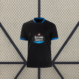 Vista frontal de la camiseta Deportivo La Coruña 26-27 visitante en color negro con cuello azul y manga corta