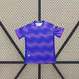 Vista frontal de la camiseta Elche 26-27 Visitante en azul y violeta con patrón gráfico ondulado, cuello redondo y manga corta