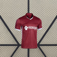 Vista frontal de la camiseta Getafe 26-27 visitante en color granate, con cuello en pico, puños blancos y patrón tonal geométrico
