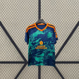Vista frontal de la camiseta Granada 26-27 visitante en azul marino con gráfico verde, cuello en V naranja y detalles naranjas en hombros