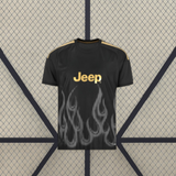 Vista frontal de la camiseta Juventus 26-27 3ª equipación negra con gráfico de llamas grises, manga corta y detalles amarillos