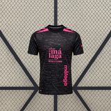 Vista frontal de la camiseta Malaga 26-27 tercera equipación en negro con detalles rosas, estampado tonal de texto y cuello redondo