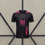 Vista frontal de la camiseta Malaga 26-27 tercera equipación en negro con detalles rosas, estampado tonal de texto y cuello redondo