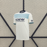 Vista frontal de la camiseta Osasuna 26-27 visitante en color blanco con franja horizontal celeste, cuello oscuro y manga corta