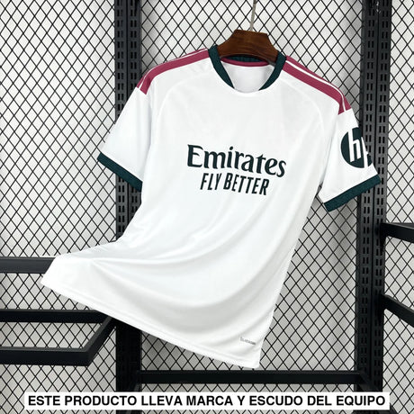 Vista frontal de la camiseta R.M. 26-27 local en color blanco, con detalles granate en los hombros, cuello verde oscuro y manga corta