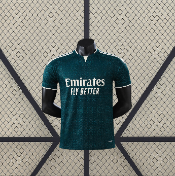 Vista frontal de la camiseta R.M. 26-27 visitante Player Version en verde oscuro, con patrón tonal, manga corta y cuello con abertura frontal