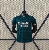 Vista frontal de la camiseta R.M. 26-27 visitante Player Version en verde oscuro, con patrón tonal, manga corta y cuello con abertura frontal