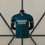 Vista frontal de la camiseta R.M. 26-27 visitante Player Version en verde oscuro, con patrón tonal, manga corta y cuello con abertura frontal