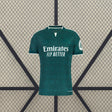Vista frontal de la camiseta R.M. 26-27 visitante en verde oscuro, con patrón tonal, cuello abierto con ribete blanco y manga corta